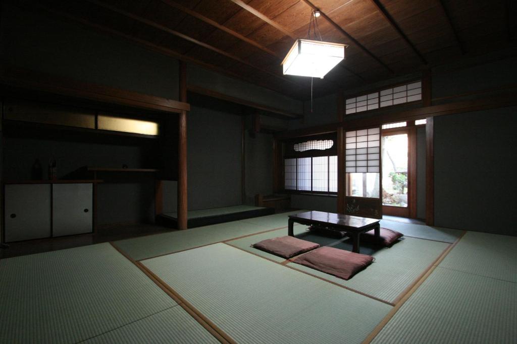 an empty room with a table and windows at HARUYA Naramachi in Nara