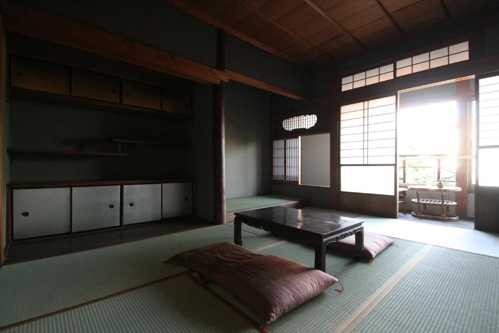 a living room with a table and a large window at HARUYA Naramachi in Nara