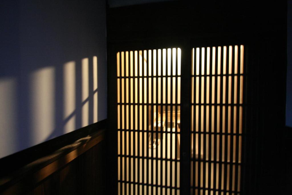 a window with bars on it with a person through it at HARUYA Naramachi in Nara
