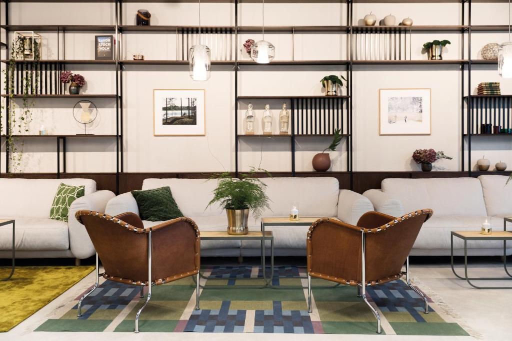 a living room with white couches and chairs at Elite Hotel Carolina Tower in Stockholm