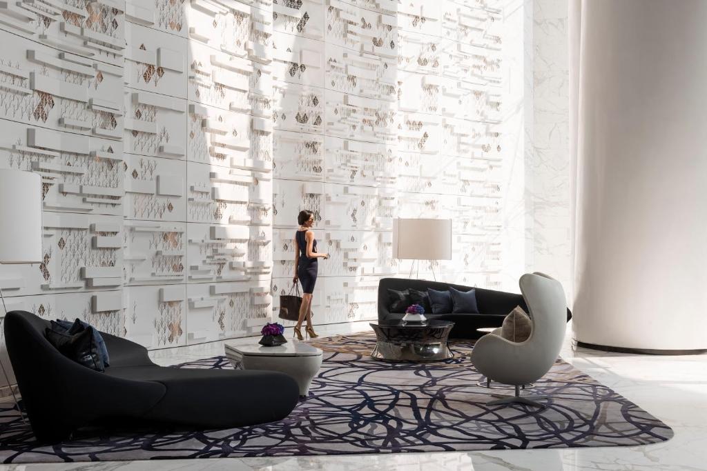 a woman standing in a living room with a white wall at Four Seasons Hotel Guangzhou in Guangzhou