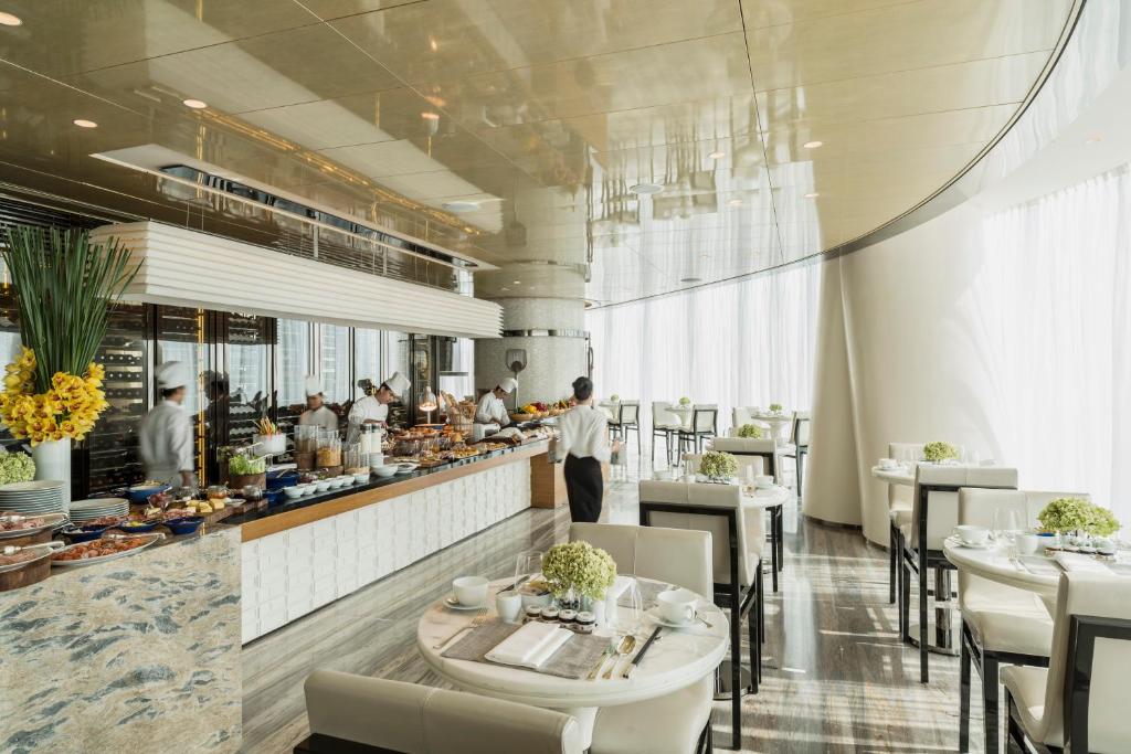 a restaurant with a chef preparing food in the kitchen at Four Seasons Hotel Guangzhou in Guangzhou