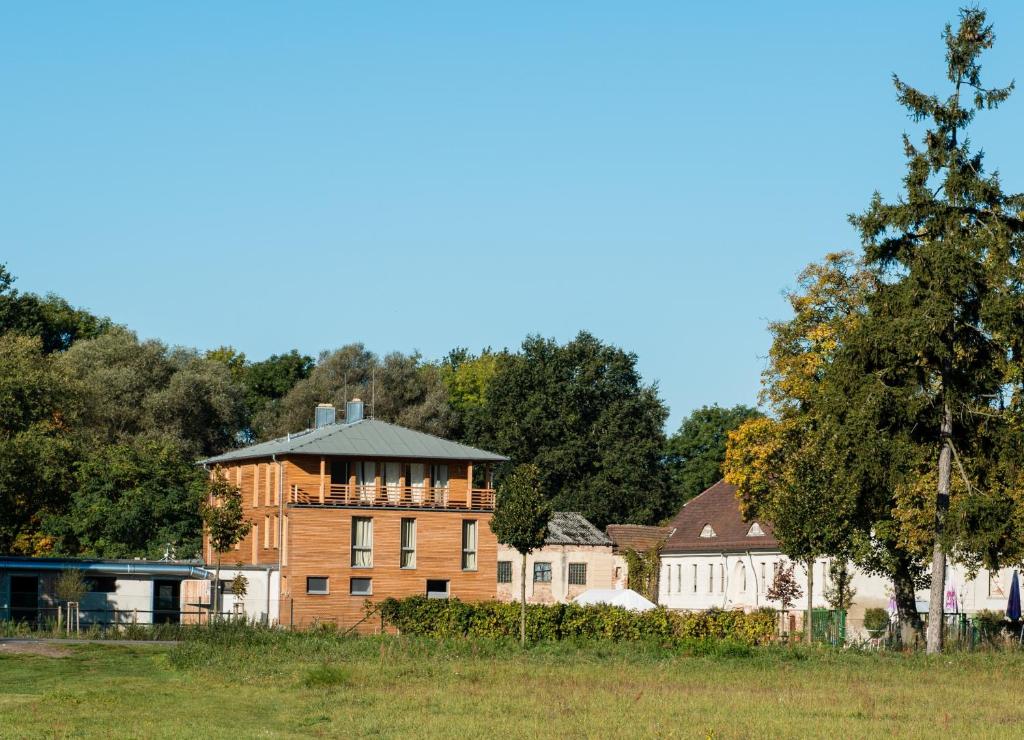 een groot bakstenen gebouw in een veld met bomen bij Gästehaus am Landgut in Schönwalde