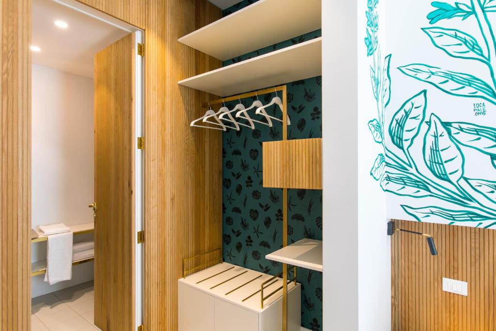 a room with a closet with green wallpaper at Horti 14 Borgo Trastevere Hotel in Rome