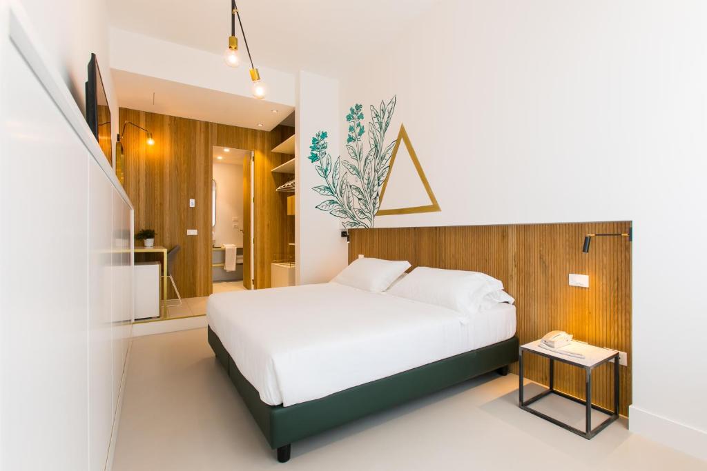 a bedroom with a white bed and a small table at Horti 14 Borgo Trastevere Hotel in Rome