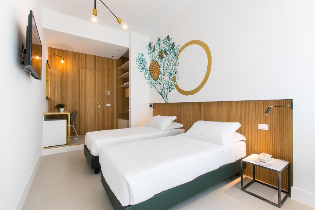 a bedroom with two beds and a tv and a table at Horti 14 Borgo Trastevere Hotel in Rome