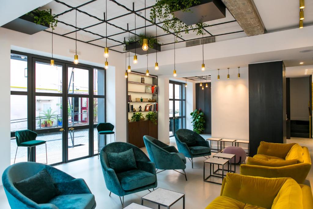 a lobby with couches chairs and tables and windows at Horti 14 Borgo Trastevere Hotel in Rome