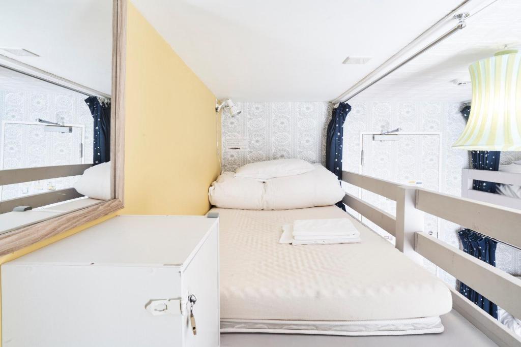 a small room with a mirror and a bed at Ten to Sen Guesthouse in Takamatsu
