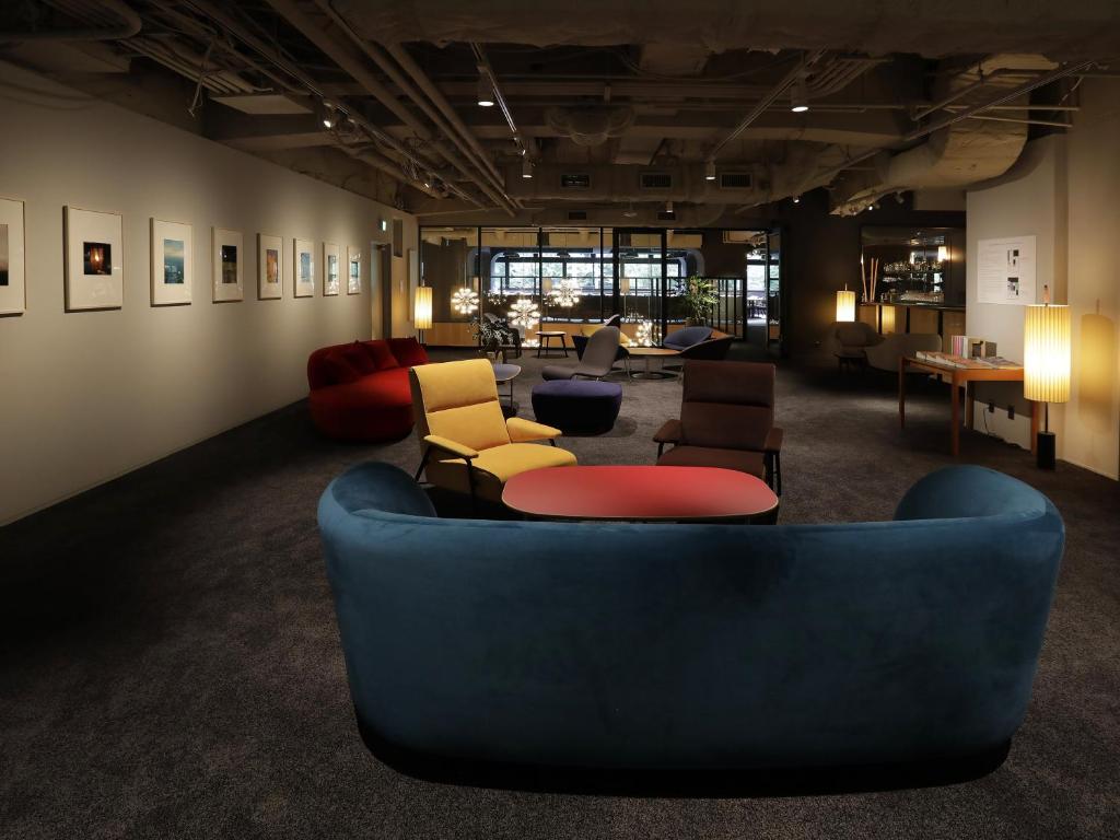 a living room with a blue couch and chairs at THE KNOT TOKYO Shinjuku in Tokyo