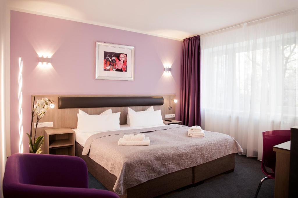 a hotel room with a bed and two chairs at Hotel Nikolai Residence in Berlin