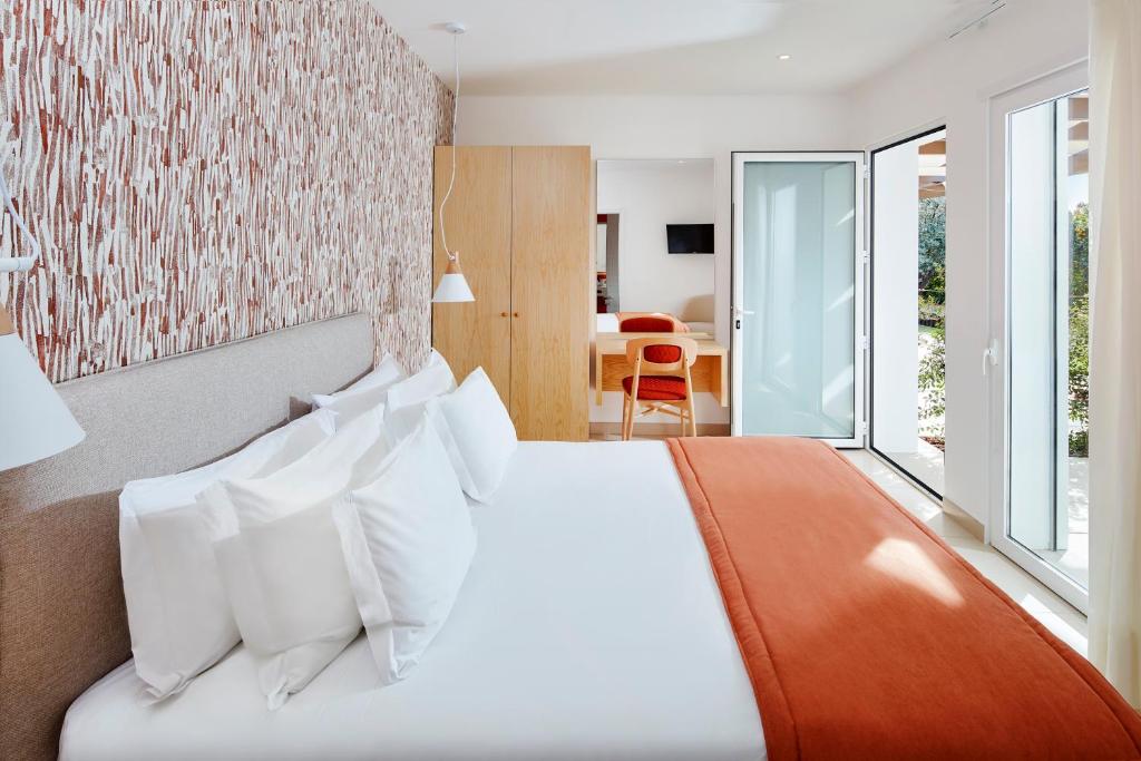a bedroom with a bed and a large window at Quinta Dos Perfumes in Tavira