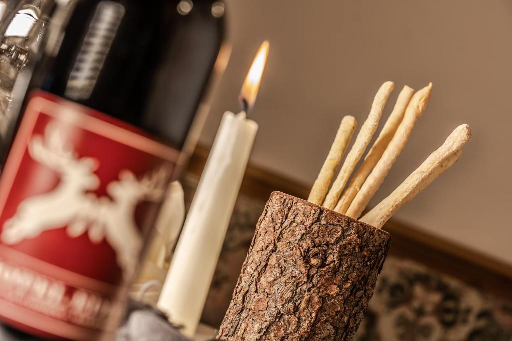 a candle and some cinnamon sticks in a vase at Hotel Edda in Selva di Val Gardena