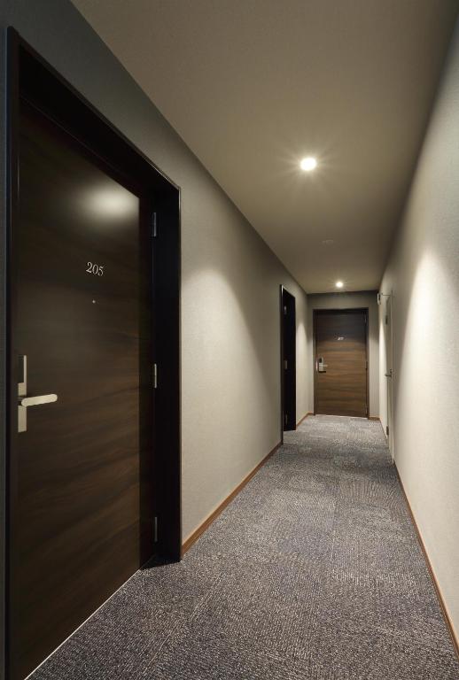 an empty corridor with a door and a hallway at HOTEL PROMOTE HIROSHIMA in Hiroshima