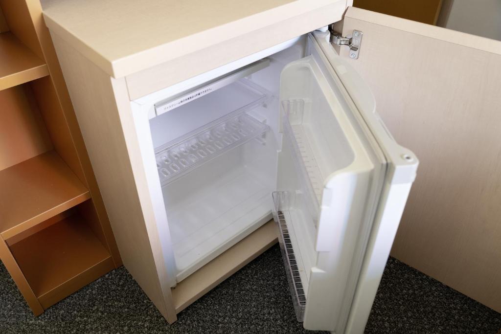 an empty refrigerator with its door open in a cabinet at Shibuya Tokyu REI Hotel in Tokyo