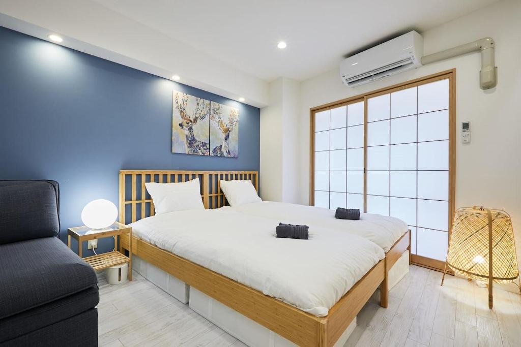a bedroom with a large bed and a couch at STAY ARI Kabukicho in Tokyo