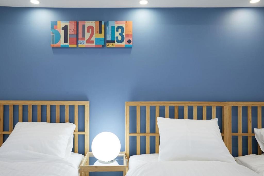 a bedroom with two beds and a blue wall at STAY ARI Kabukicho in Tokyo