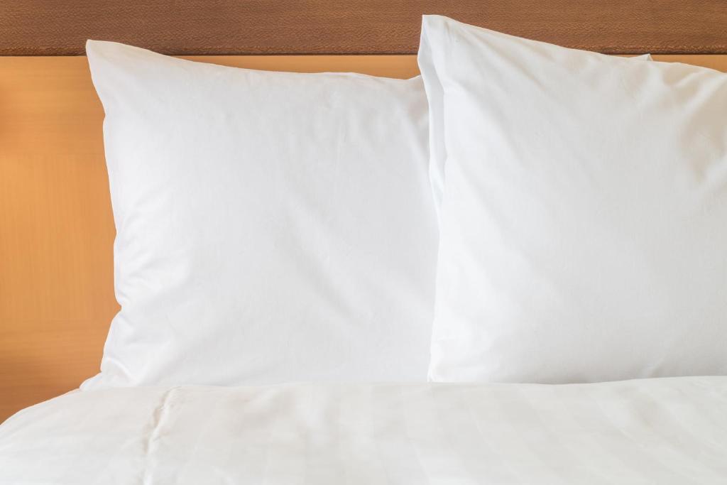 a stack of white pillows on a bed at Holiday Inn Express & Suites Duluth North - Miller Hill by IHG in Duluth