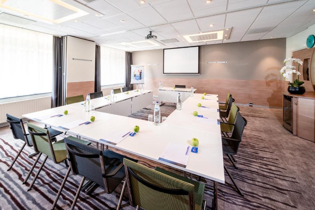 a conference room with a long table and chairs at Novotel Rotterdam - Schiedam in Schiedam