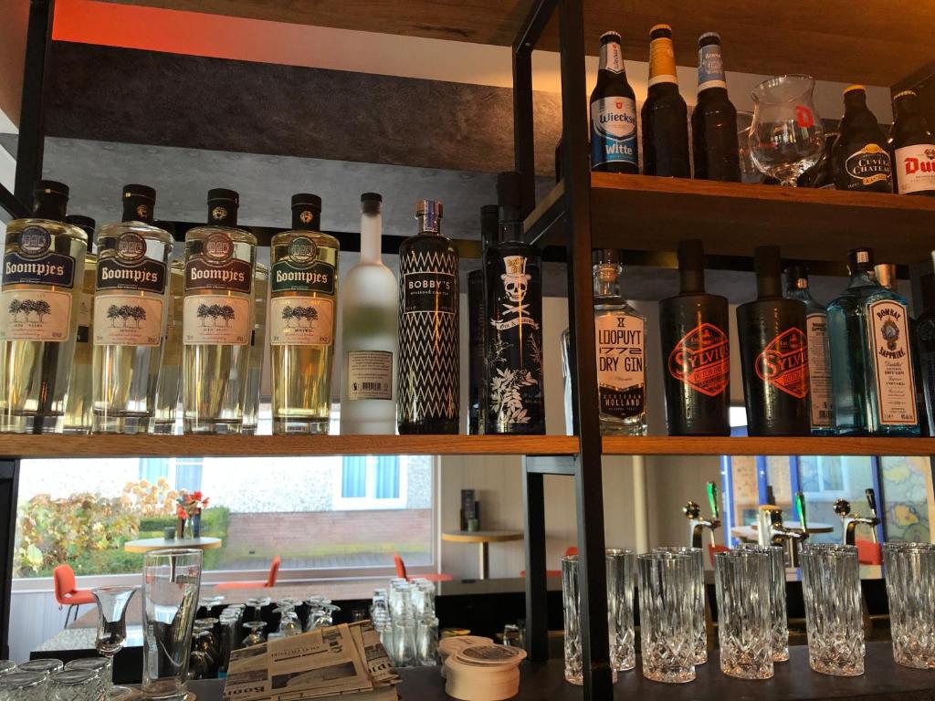 a bar with lots of bottles of alcohol on shelves at Novotel Rotterdam - Schiedam in Schiedam