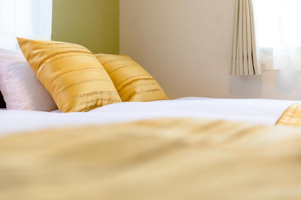 a close up of a bed with two pillows at Bon Moment B棟-桜館 in Fujikawaguchiko