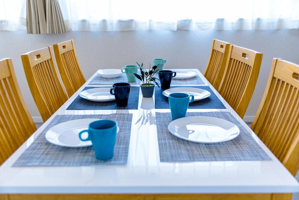 a table with plates and cups on top at Bon Moment B棟-桜館 in Fujikawaguchiko