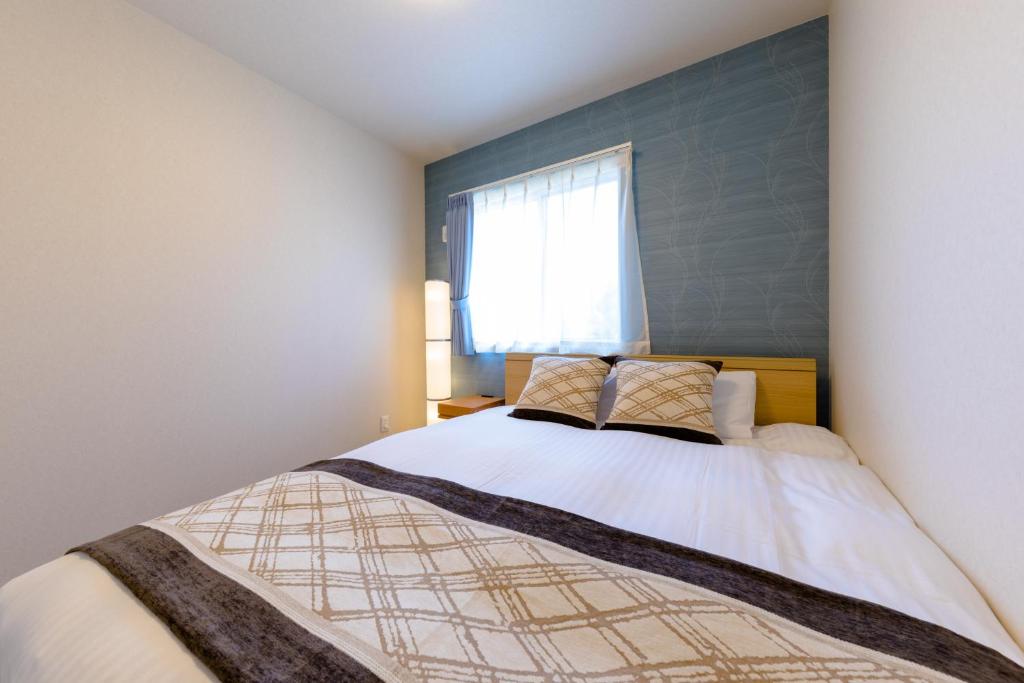 a bedroom with a large bed with a window at Bon Moment B棟-桜館 in Fujikawaguchiko