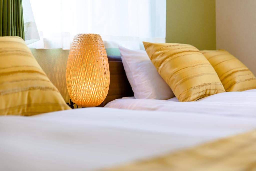 a bedroom with two beds with pillows and a lamp at Bon Moment B棟-桜館 in Fujikawaguchiko
