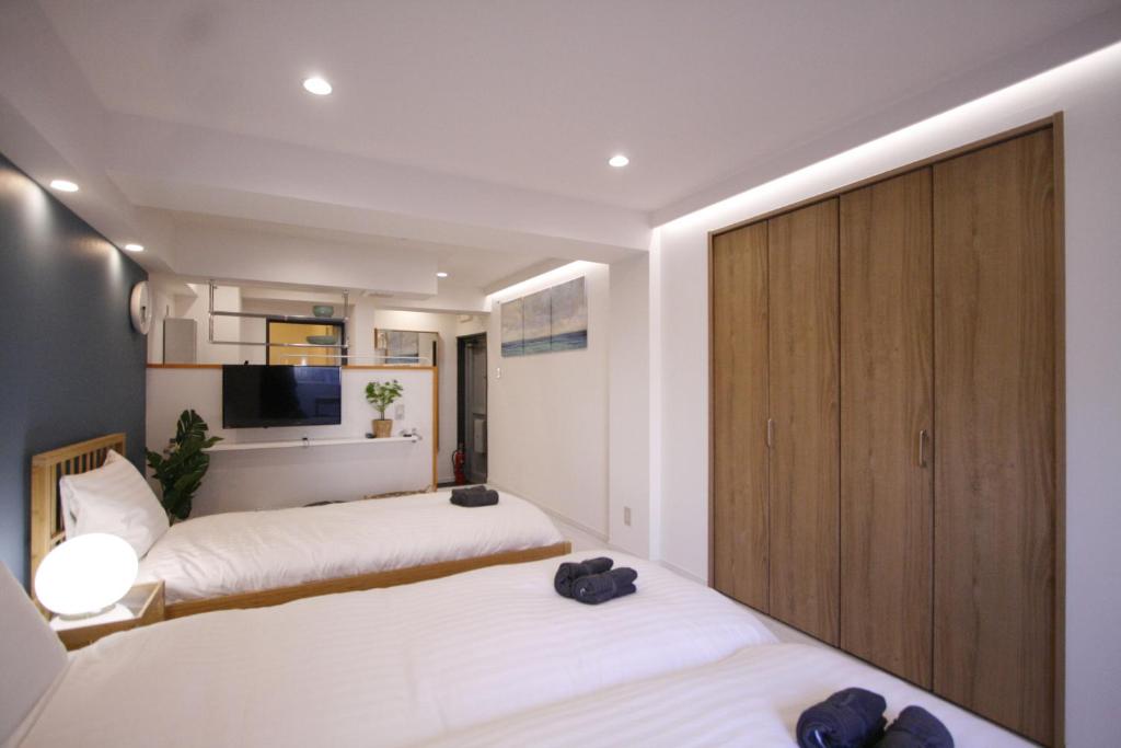 a bedroom with two beds and a cabinet at STAY ARI Kabukicho in Tokyo