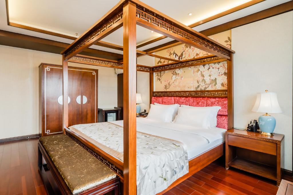 een slaapkamer met een hemelbed en een lamp bij Buddha Zen Hotel in Chengdu