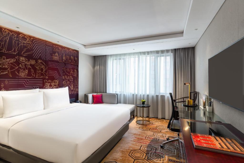 a hotel room with a large bed and a television at China Hotel Guangzhou - Subway direct to Pazhou Exhibition Center, Free shuttle during Canton Fair & Exhibitor registration Counter in Guangzhou