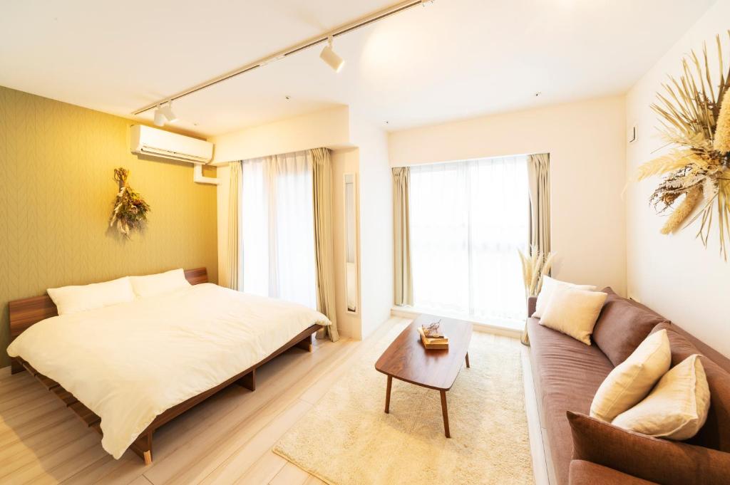 a bedroom with a bed and a couch at GIVE Higashi Nakano in Tokyo