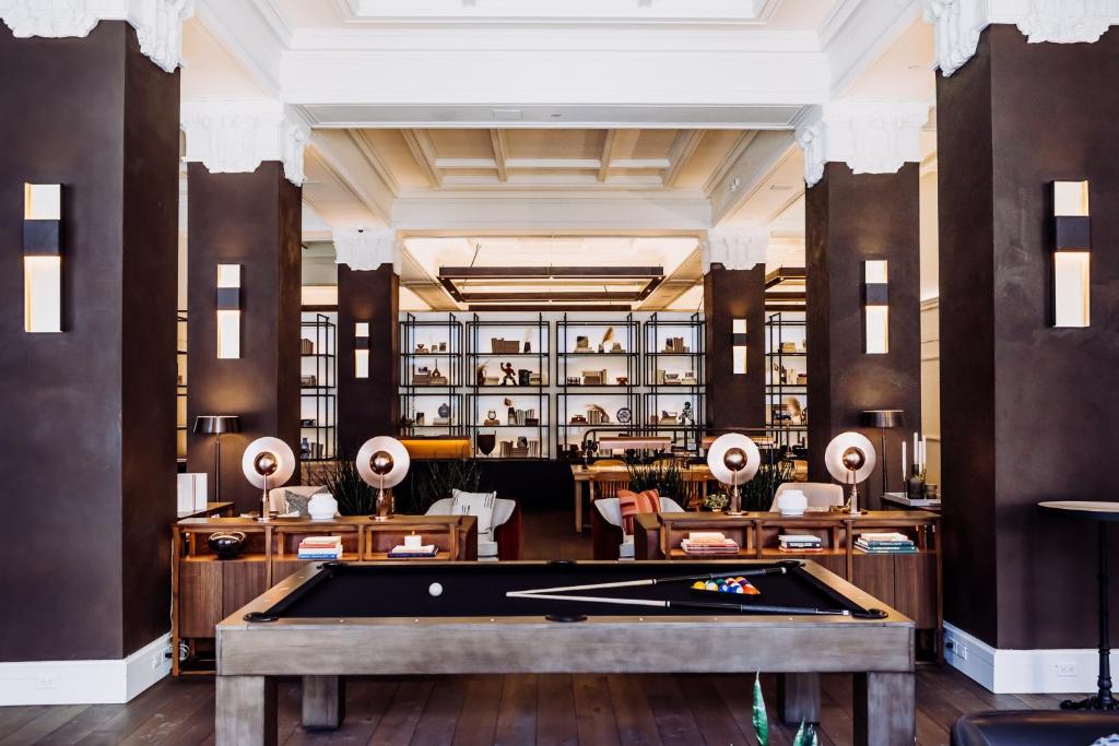 a pool table in a room with a library at Surety Hotel in Des Moines