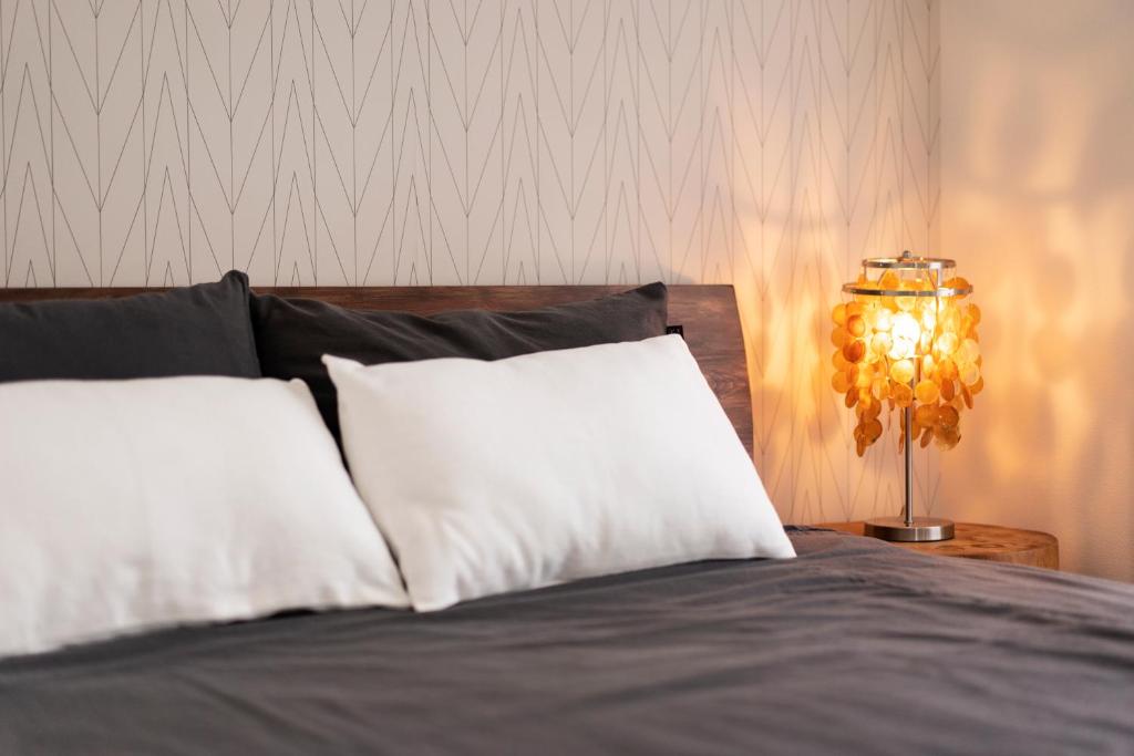 a bed with a white pillow and a lamp at GIVE Higashi Nakano in Tokyo