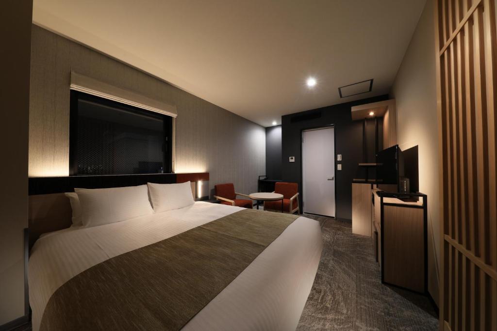 a hotel room with a bed and a television at Almont Hotel Nippori in Tokyo