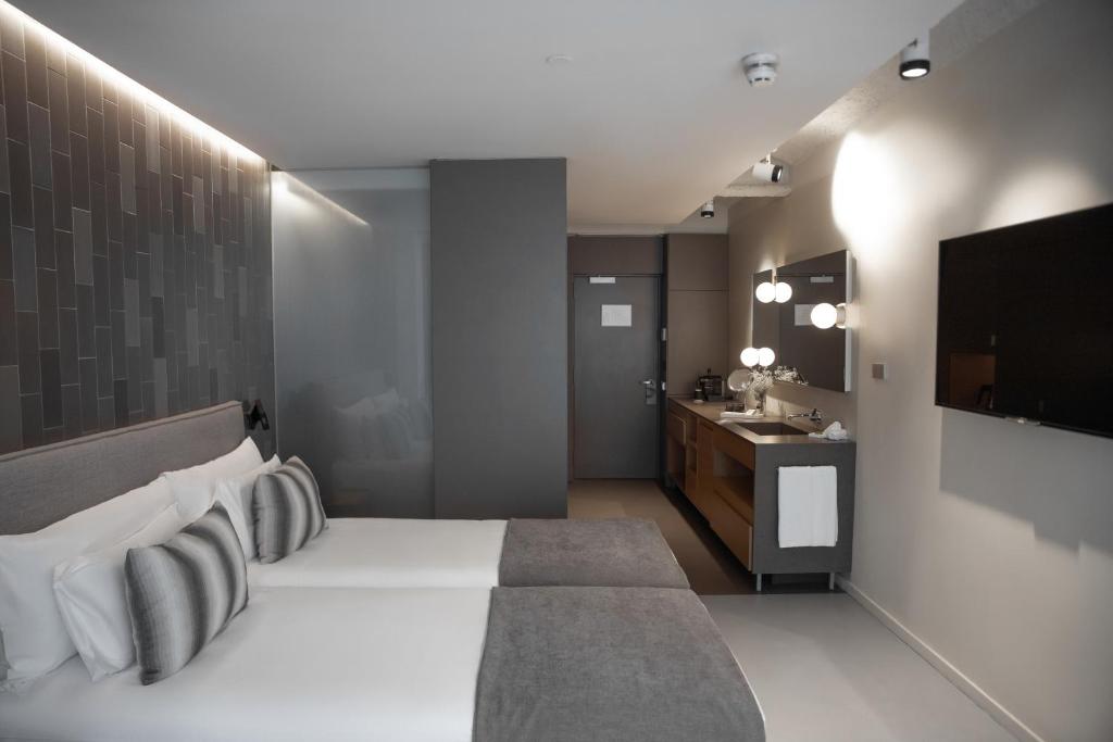 a bedroom with a bed and a sink and a television at Ohla Eixample in Barcelona