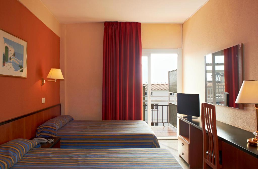BLUESEA Copacabana في يوريت دي مار: غرفه فندقيه بسرير ونافذه