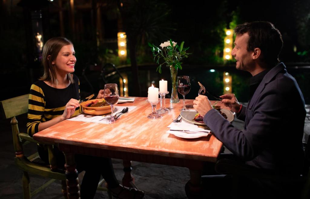 a man and woman sitting at a table with wine glasses at Hotel Santa Cruz Plaza in Santa Cruz