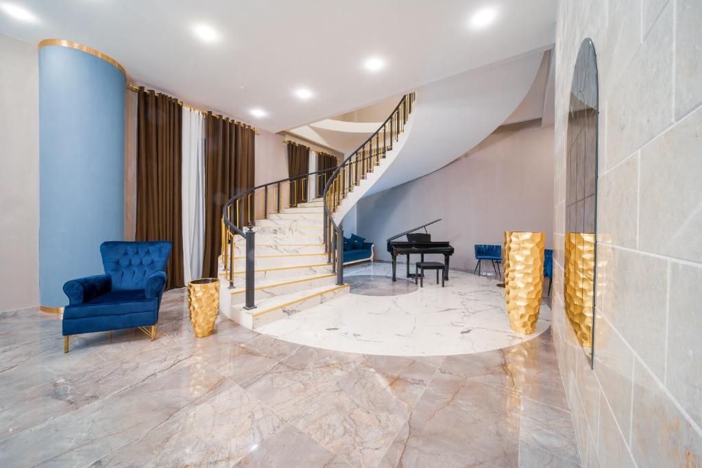 a living room with a staircase and a piano at Hotel Residence Plaza in Tbilisi City