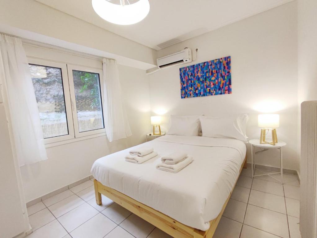 una camera da letto con un letto bianco con due asciugamani sopra di Avli apartment ad Atene