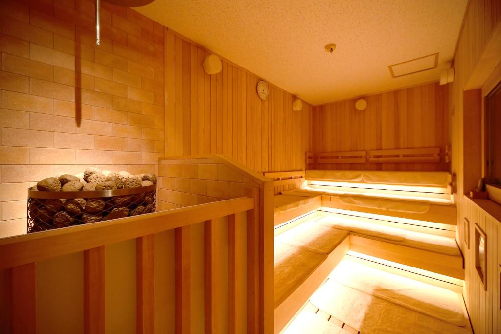 a sauna with two beds and a bowl of logs at The Centurion Hotel & Spa Classic Izumo in Izumo