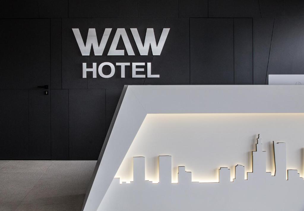 einem weißen Tisch vor einem Hotelschild in der Unterkunft Waw Hotel Airport Okęcie in Warschau