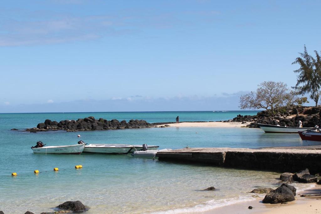 two boats in the water next to a beach at Auberge Miko in Grand Baie
