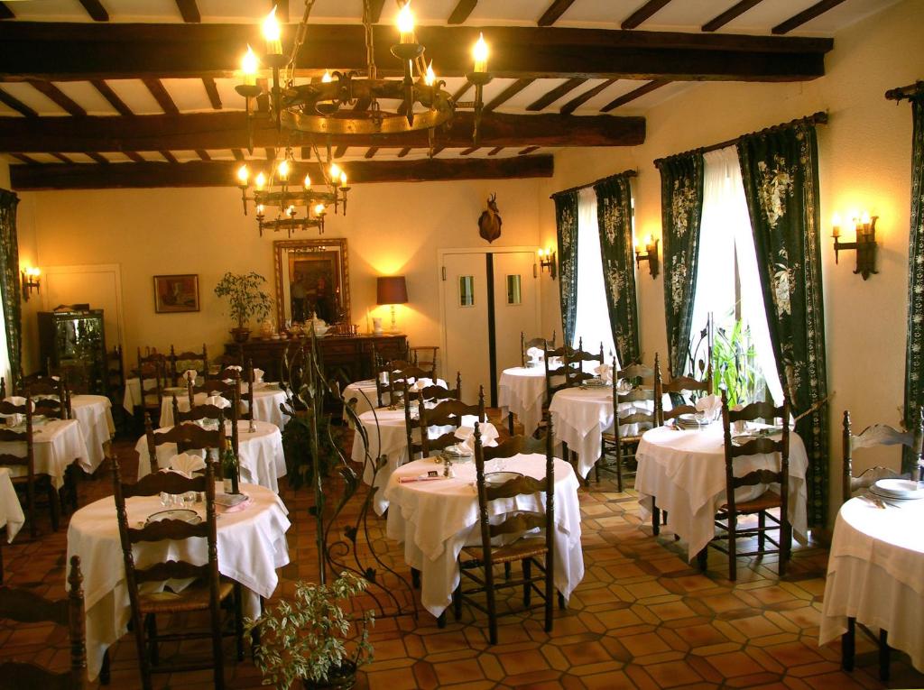 a dining room with tables with white table cloth at Logis Hôtel Beau Site in Argelès-Gazost