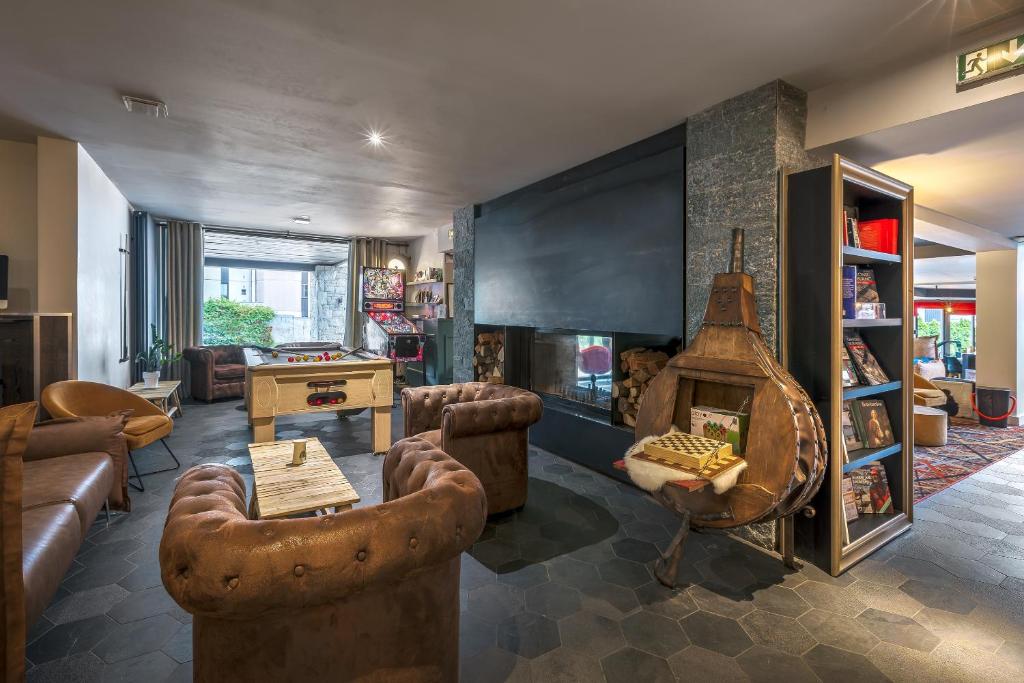 a living room with a couch and a fireplace at Chalet Hôtel Le Prieuré & Spa in Chamonix