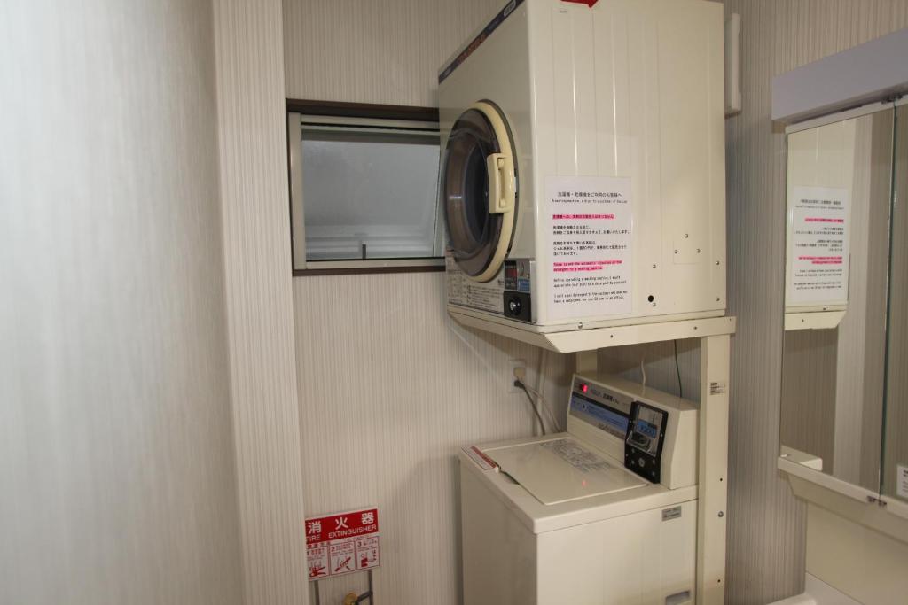 a bathroom with a machine and a window in it at Guesthouse Haru Kitamachi in Nara