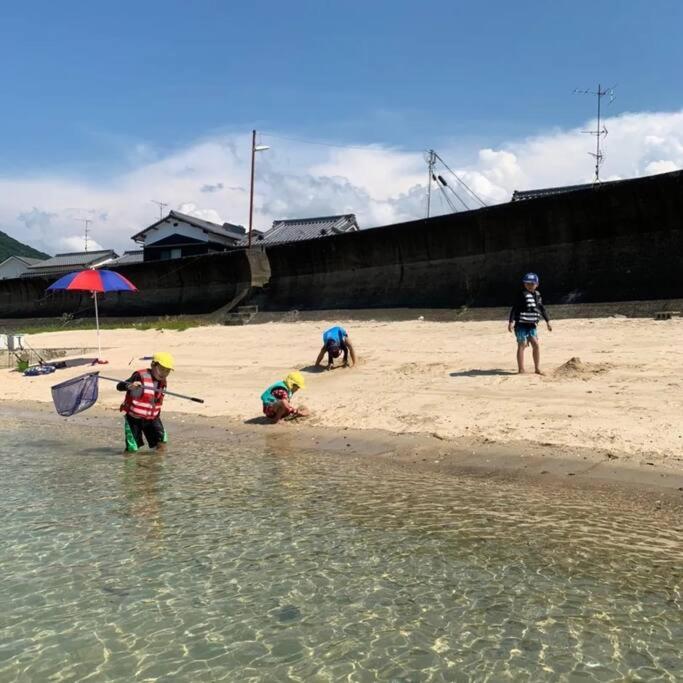 a group of children playing in the sand on the beach at 風早邸海音 kazahayatei mion in Hōjō