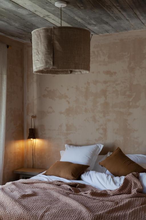 a bedroom with a bed with pillows and a ceiling at Azenhas do Mar Valley House in Sintra