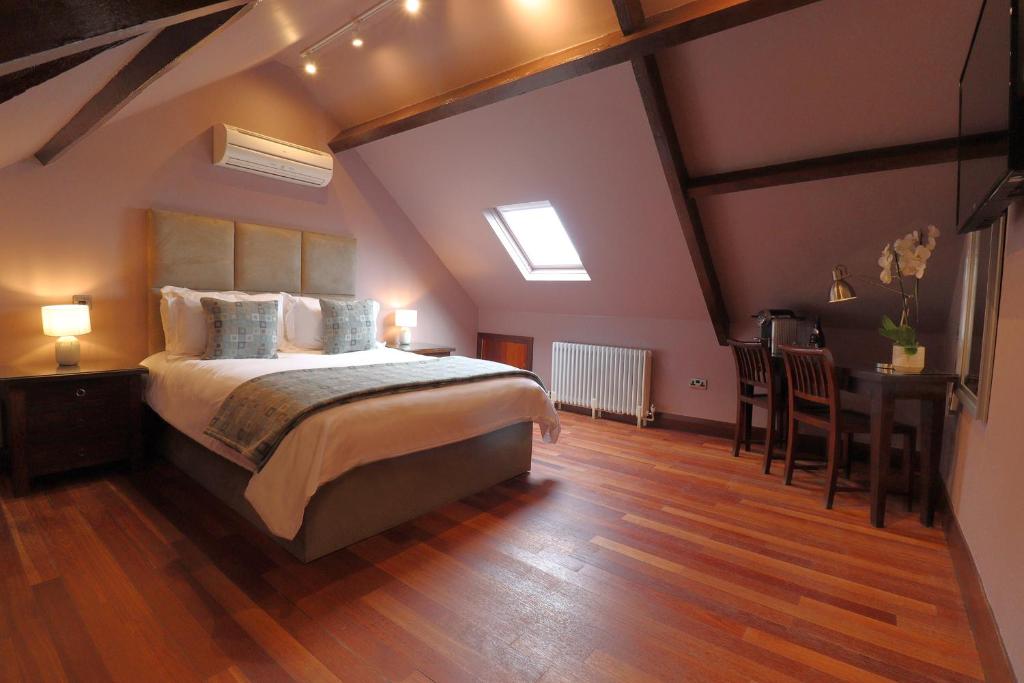 a bedroom with a large bed and a desk in a room at Morgans Hotel in Swansea