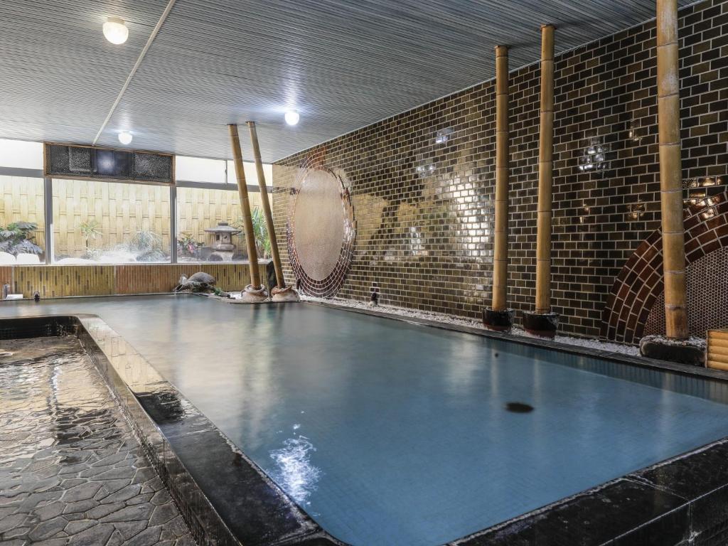 a large swimming pool in a building with a swimming pool at Ohashikan in Matsue