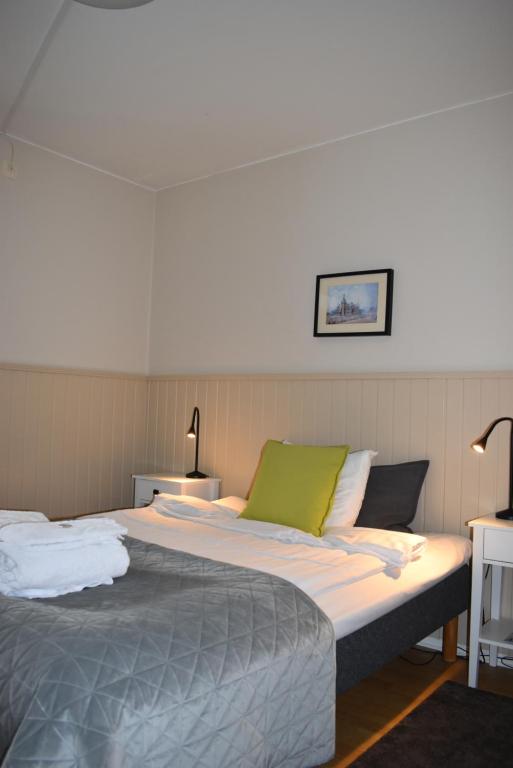 a bedroom with a large bed with a green pillow at STF Wendelsberg Hotel & Hostel in Mölnlycke